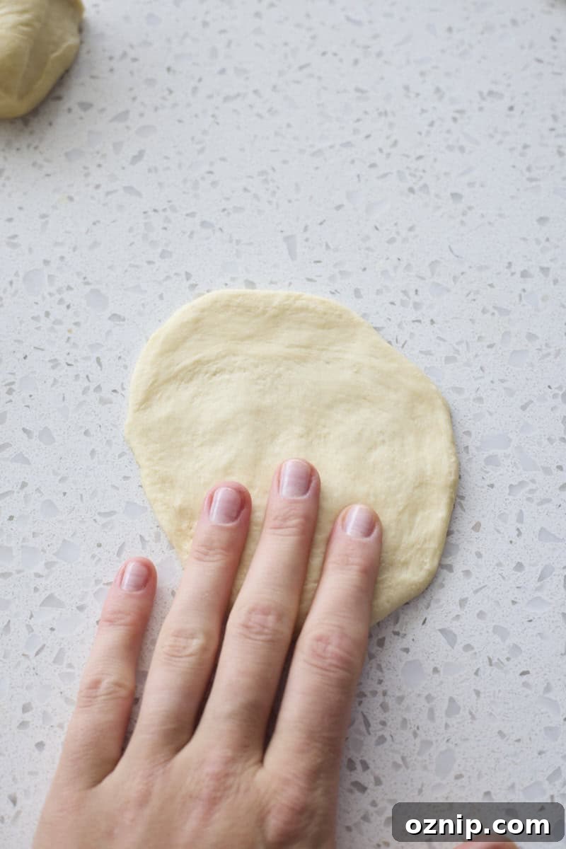 Dough piece flattened by hand.