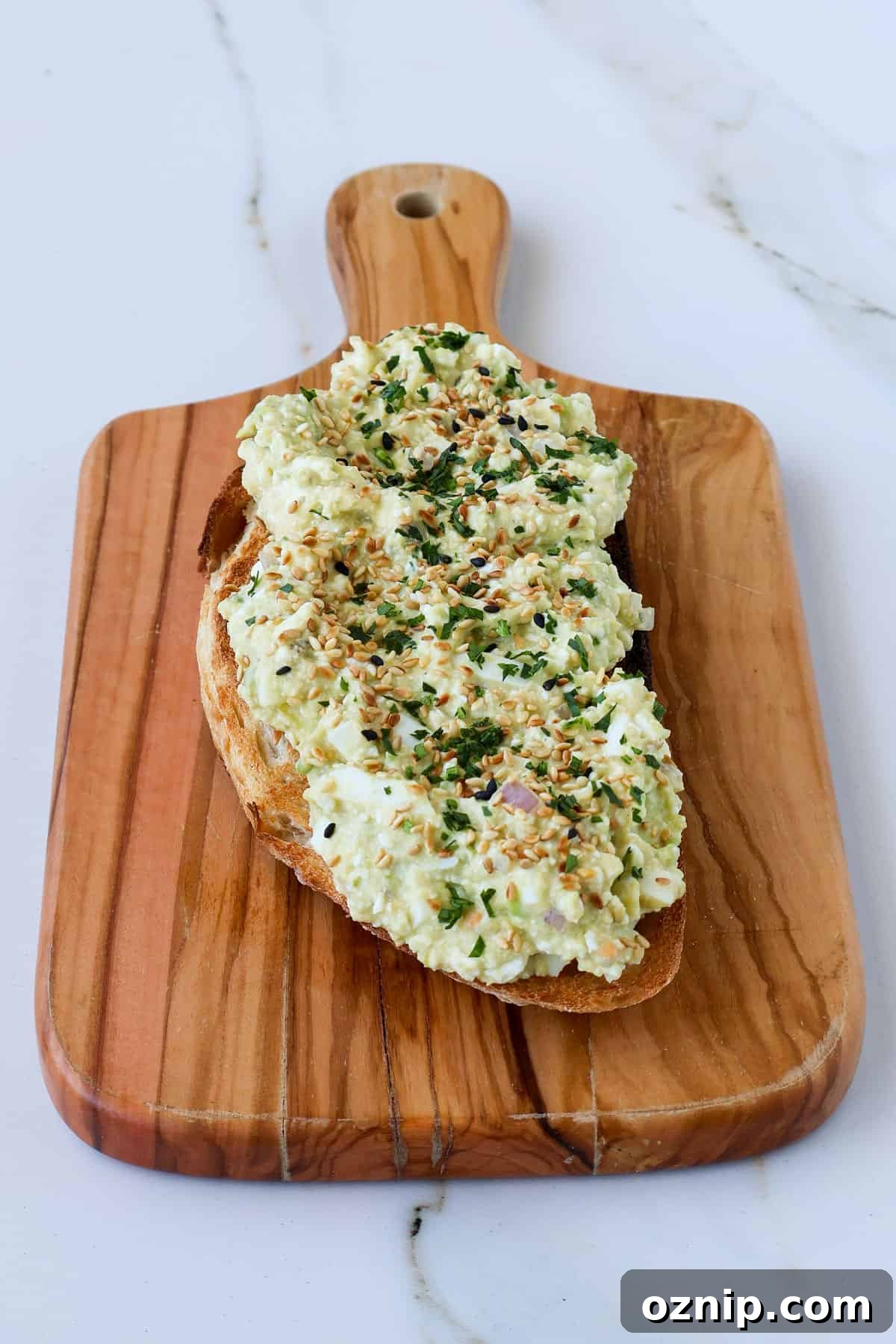 Cottage Cheese and Avocado Toast Recipe for Brunch 8 Side shot of cottage cheese avocado toast on a wooden board.