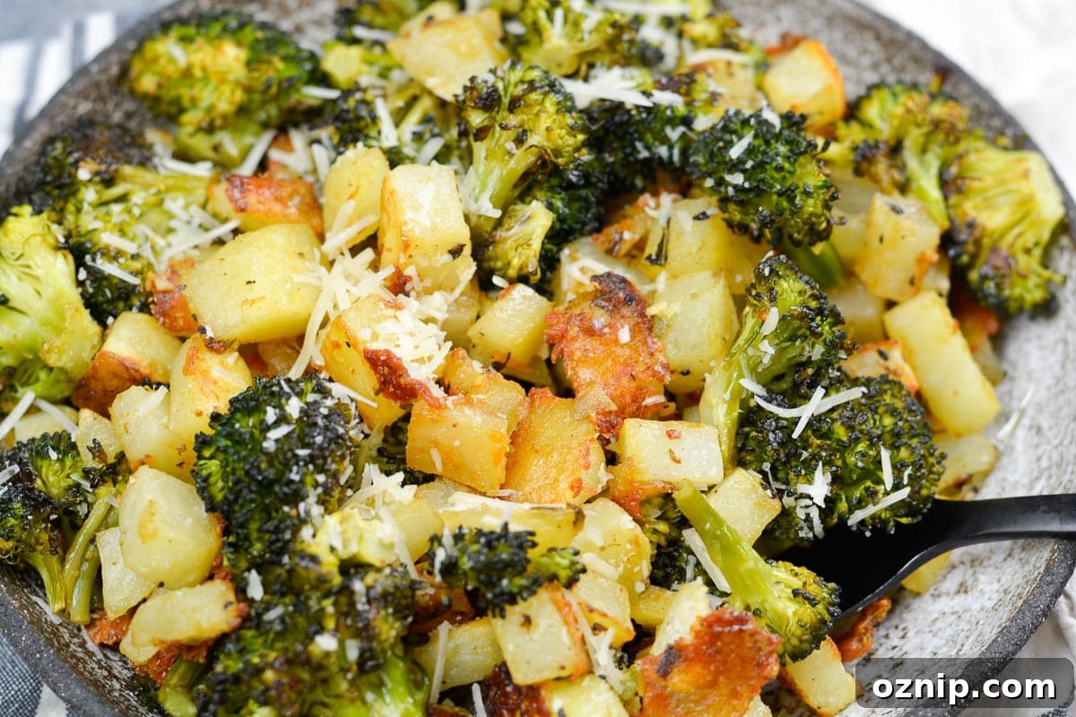 Crispy Oven-Roasted Vegetables with Garlic and Herbs 9 a spoon gathering a bite of lemon dijon roasted potatoes and broccoli for an easy vegetable side dish