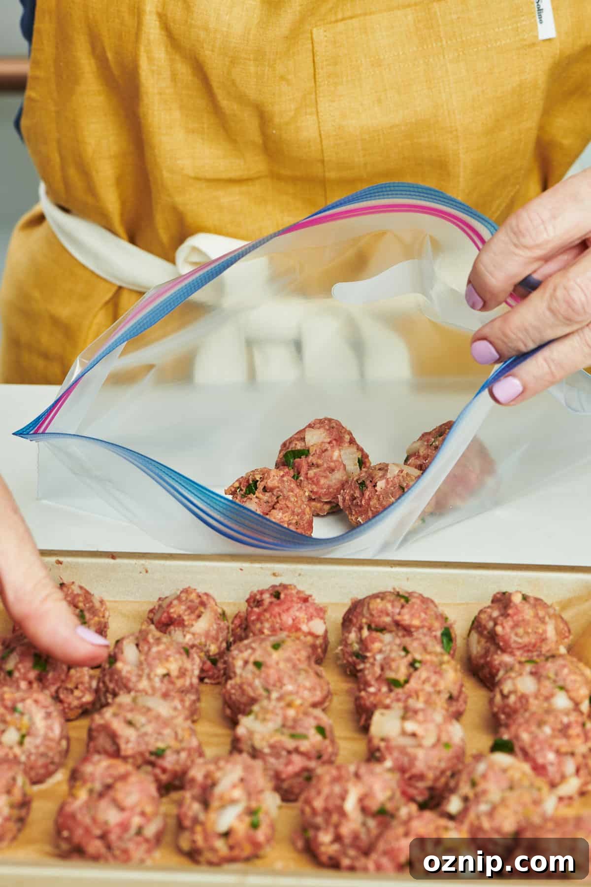 Woman placing meatballs into freezer bag.
