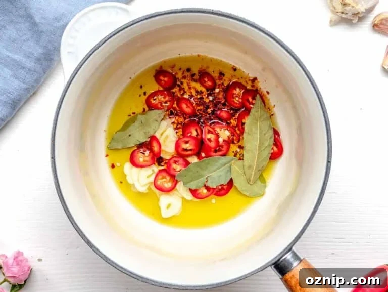 making tadka in a saucepan with oil, aromatics and spices