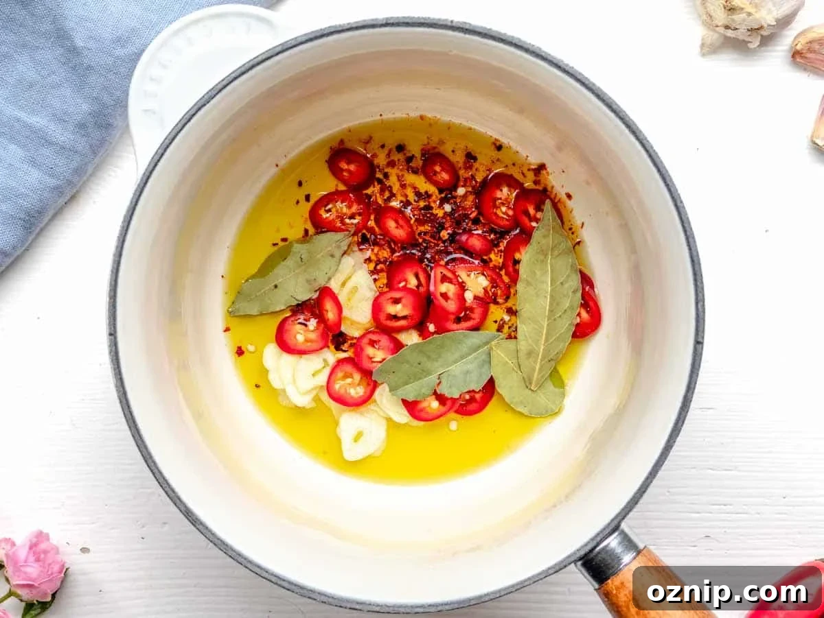 making tadka in a saucepan with oil, aromatics and spices