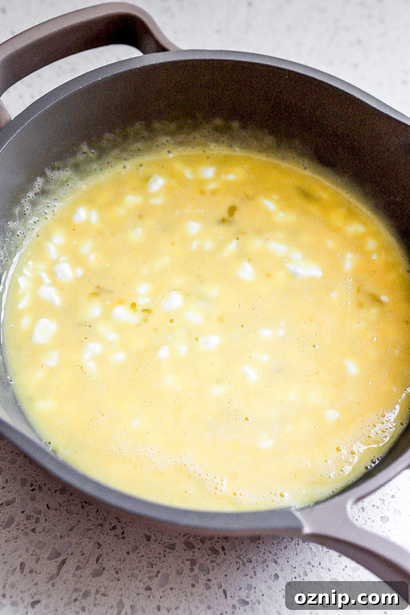 Side angle of eggs in a small frying pan.