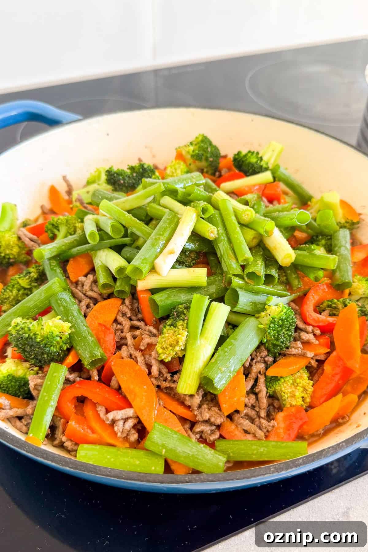 Teriyaki Beef Bowls with Rice and Vegetables 8 Spring onions and teriyaki sauce added to the pan.