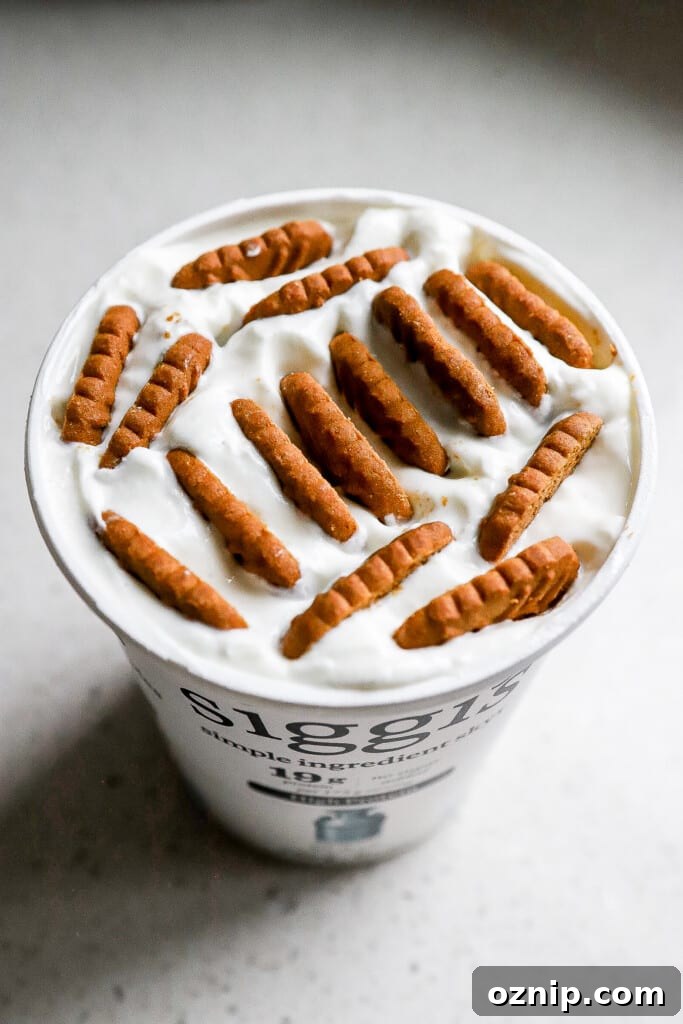 Side angle of biscoff cookies in large yogurt tub with lid off.