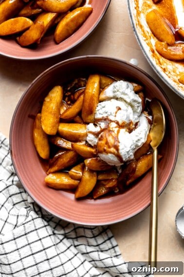 Overhead image of fried apples served in a bowl topped with a scoop of vanilla ice cream.