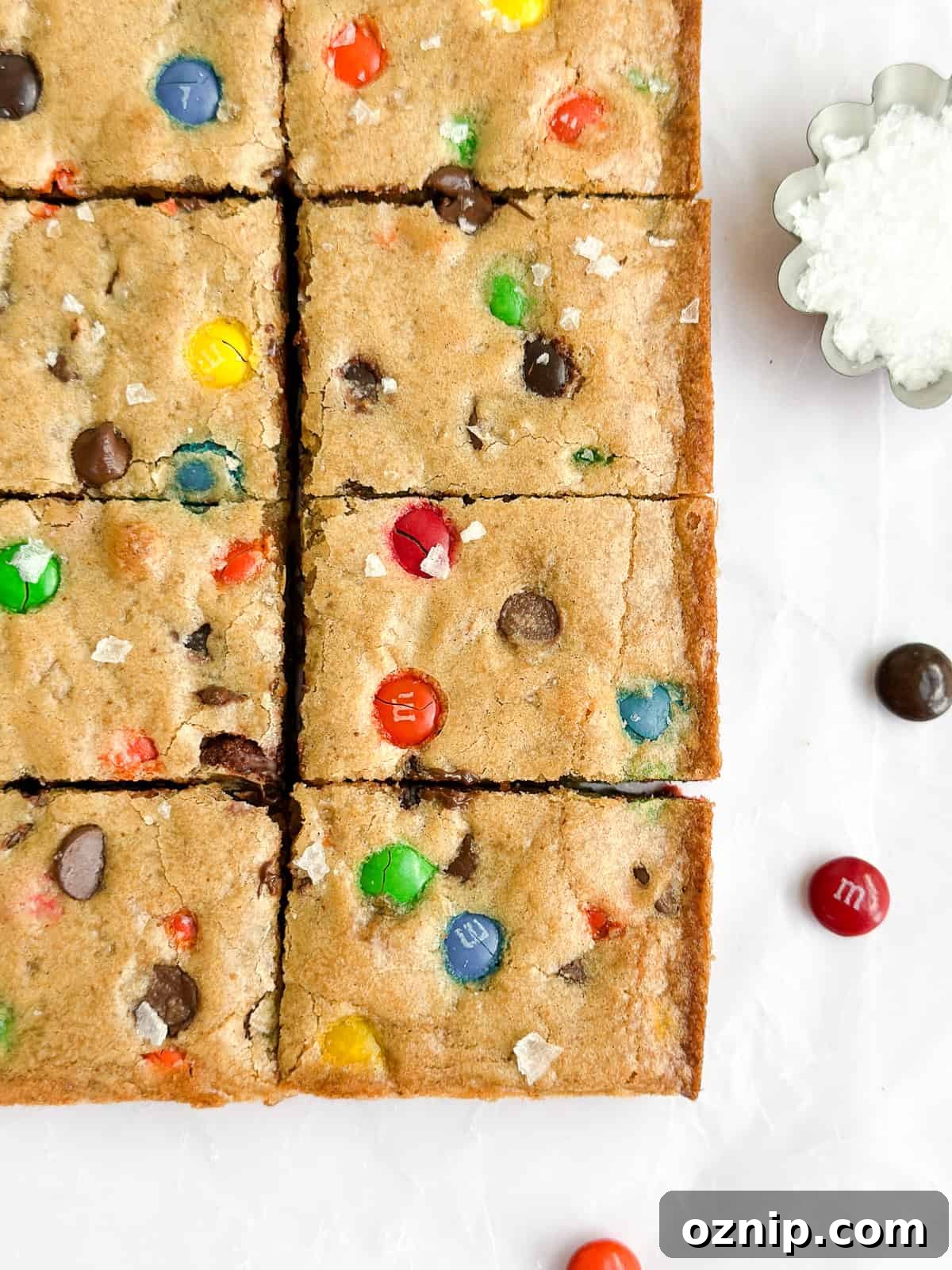 Browned Butter M&M Blondies 11 a close up of the browned butter m&m blondies with a little salt on the side.