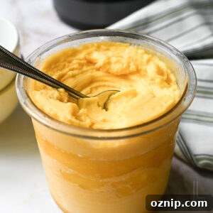 2 Ingredient Ninja Creami Mango Sorbet Recipe 13 a ninja creami pint container of mango sorbet, after spinning, with a spoon.
