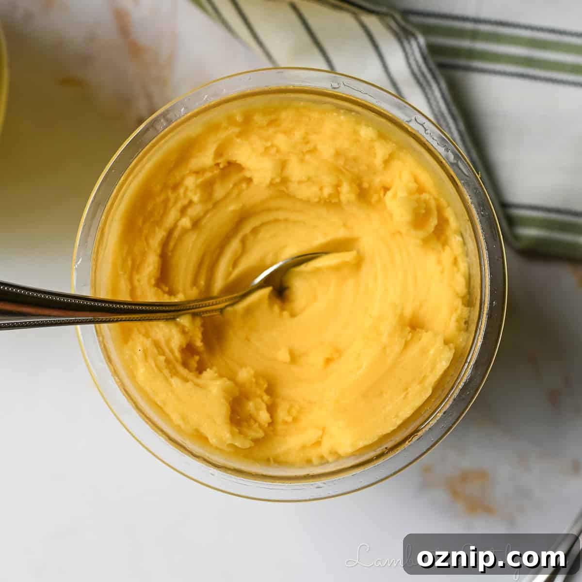 2 Ingredient Ninja Creami Mango Sorbet Recipe 7 mango sorbet in a Ninja Creami pint container, after spinning, with a spoon in it.