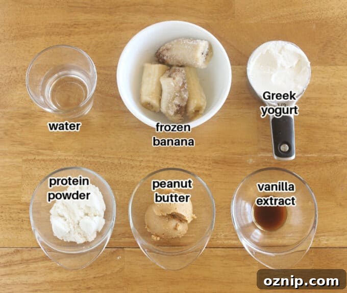Ingredients laid out on a table, including banana, Greek yogurt, and peanut butter.