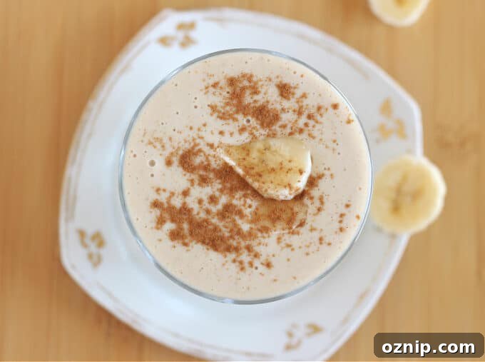 Top down view of smoothie with cinnamon and banana on top.
