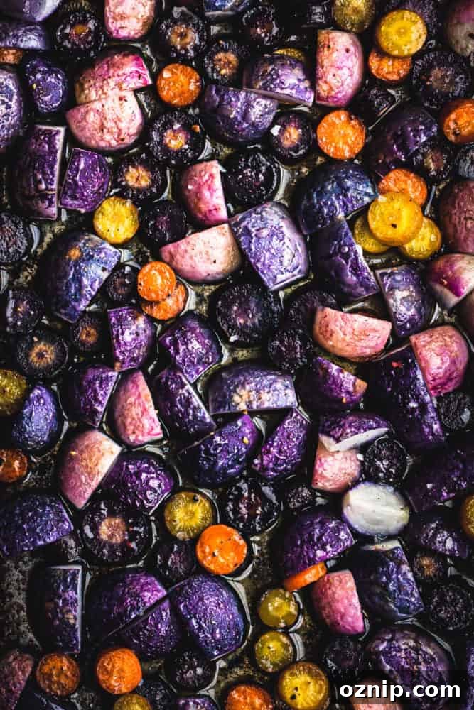 Roasted radishes and carrots on a baking sheet, overhead shot. 