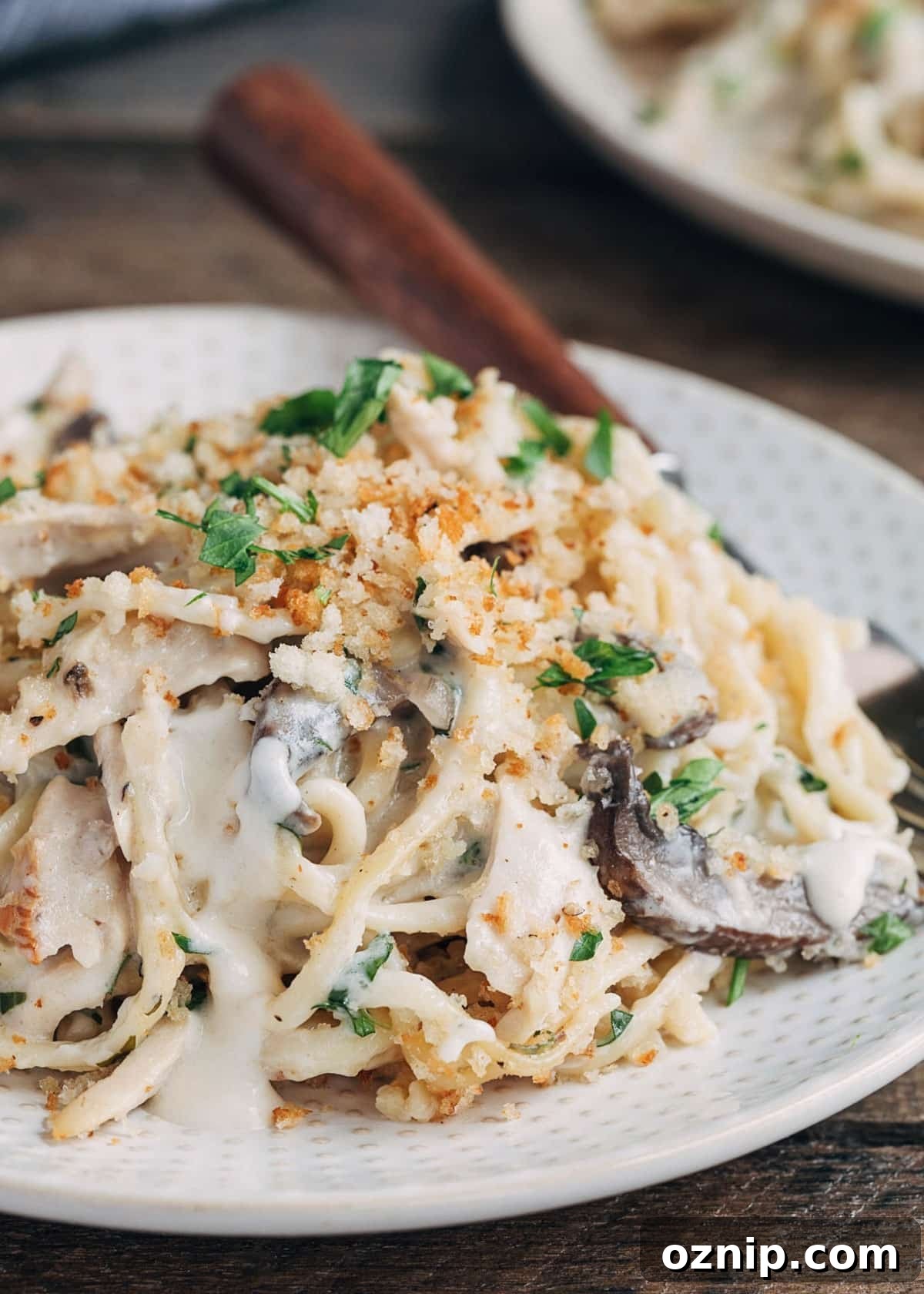 closeup of turkey tetrazzini on a plate with mushrooms and peas