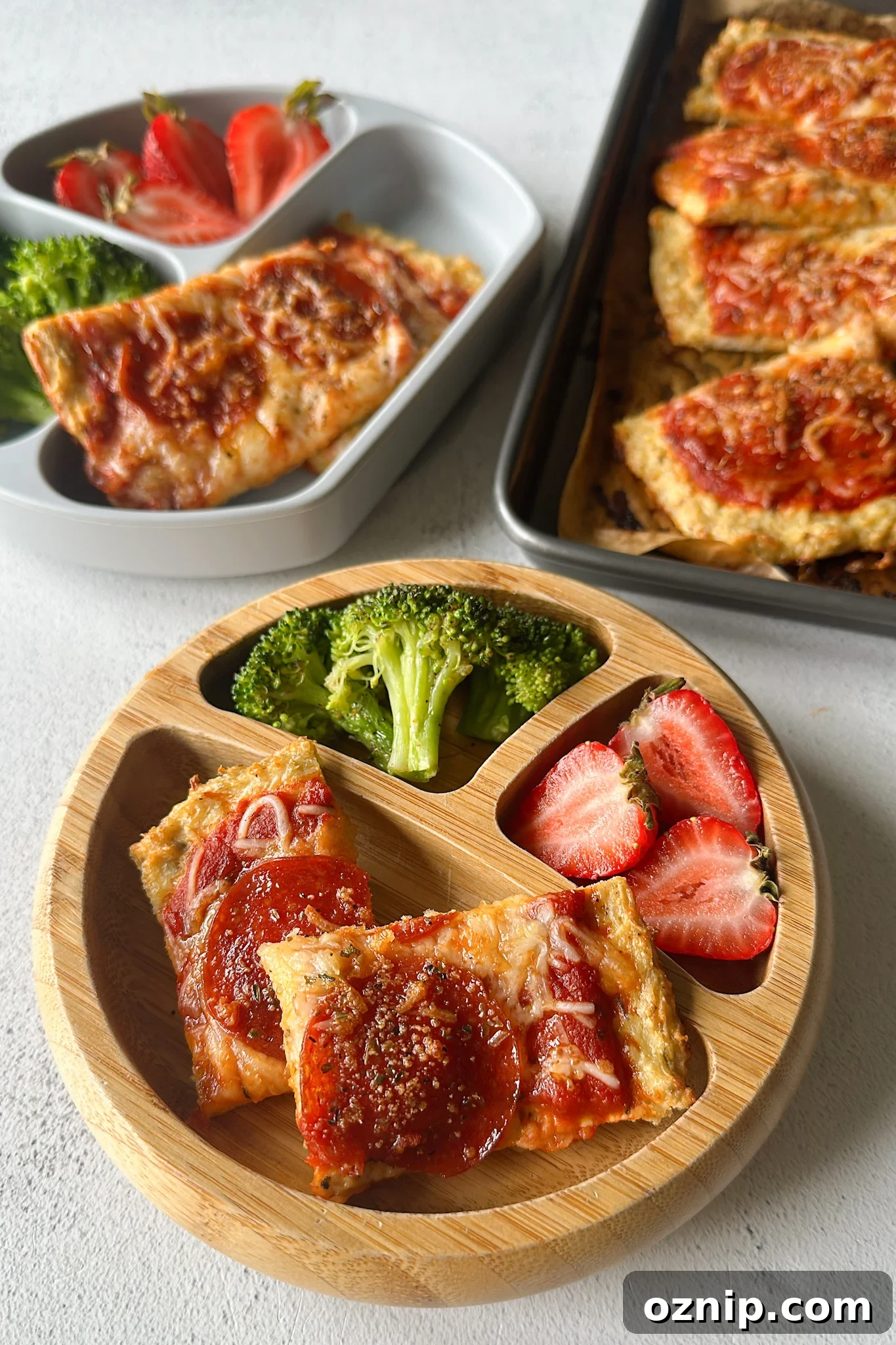 Chicken crust pizza served with broccoli and strawberries.