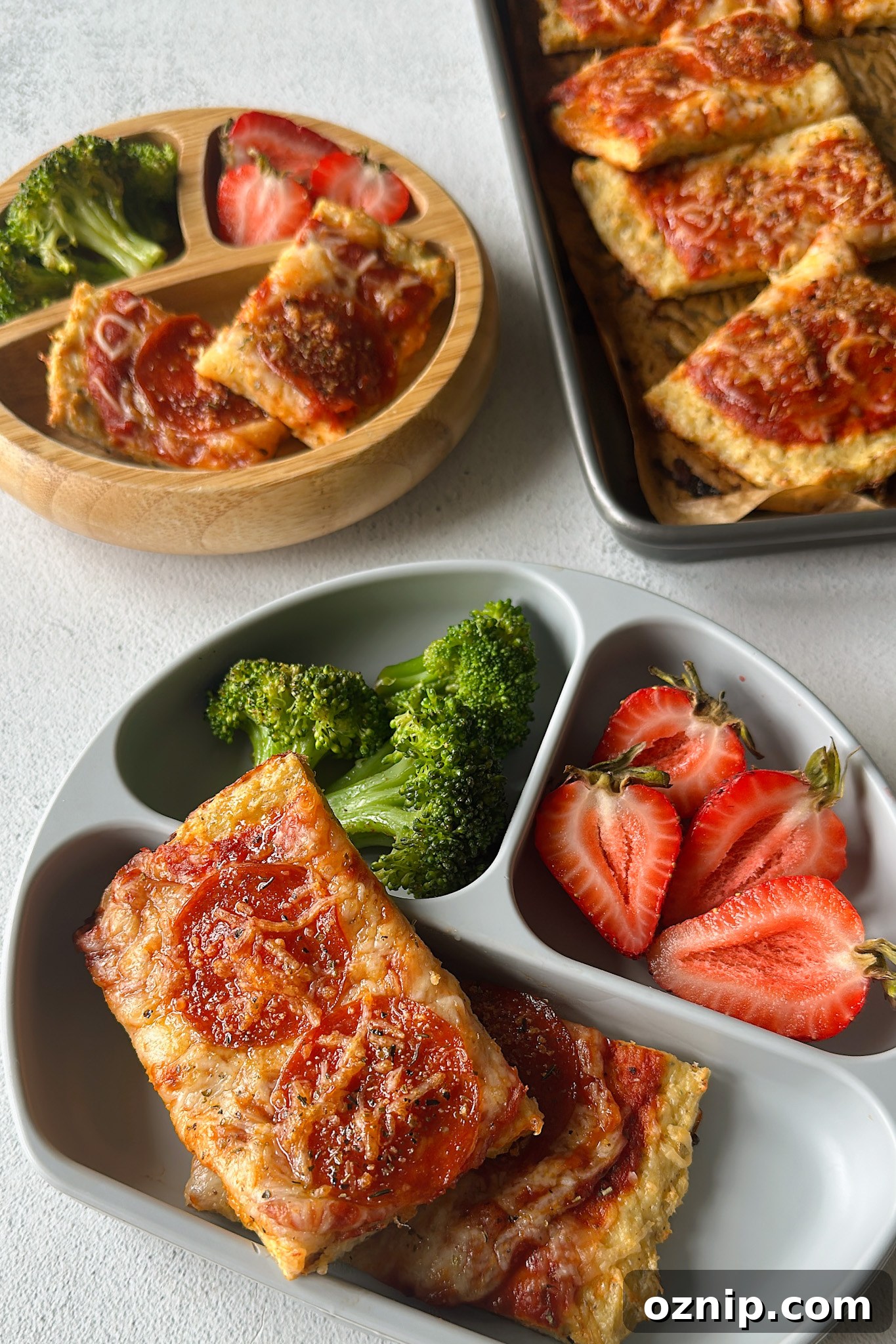 Chicken crust pizza served with broccoli and strawberries.