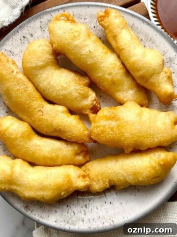 overhead shot of chicken fingers on plate with bowl of sweet and sour sauce on the side