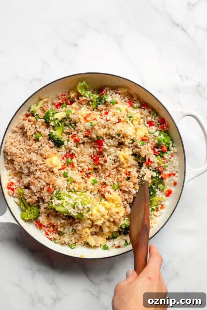 adding scrambled eggs to fried rice