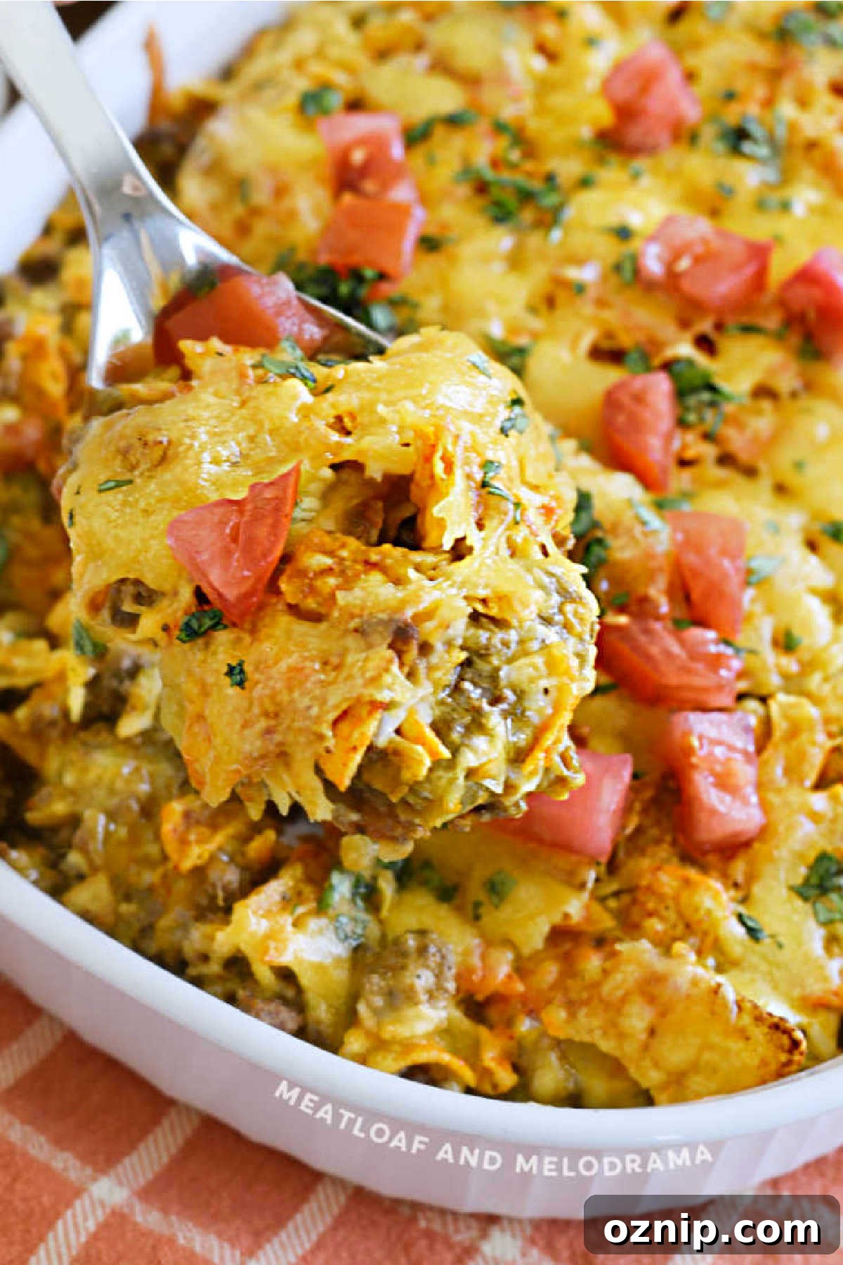 Cheesy Doritos and Ground Beef Casserole 8 Dorito Casserole with ground beef and tomatoes on a serving spoon