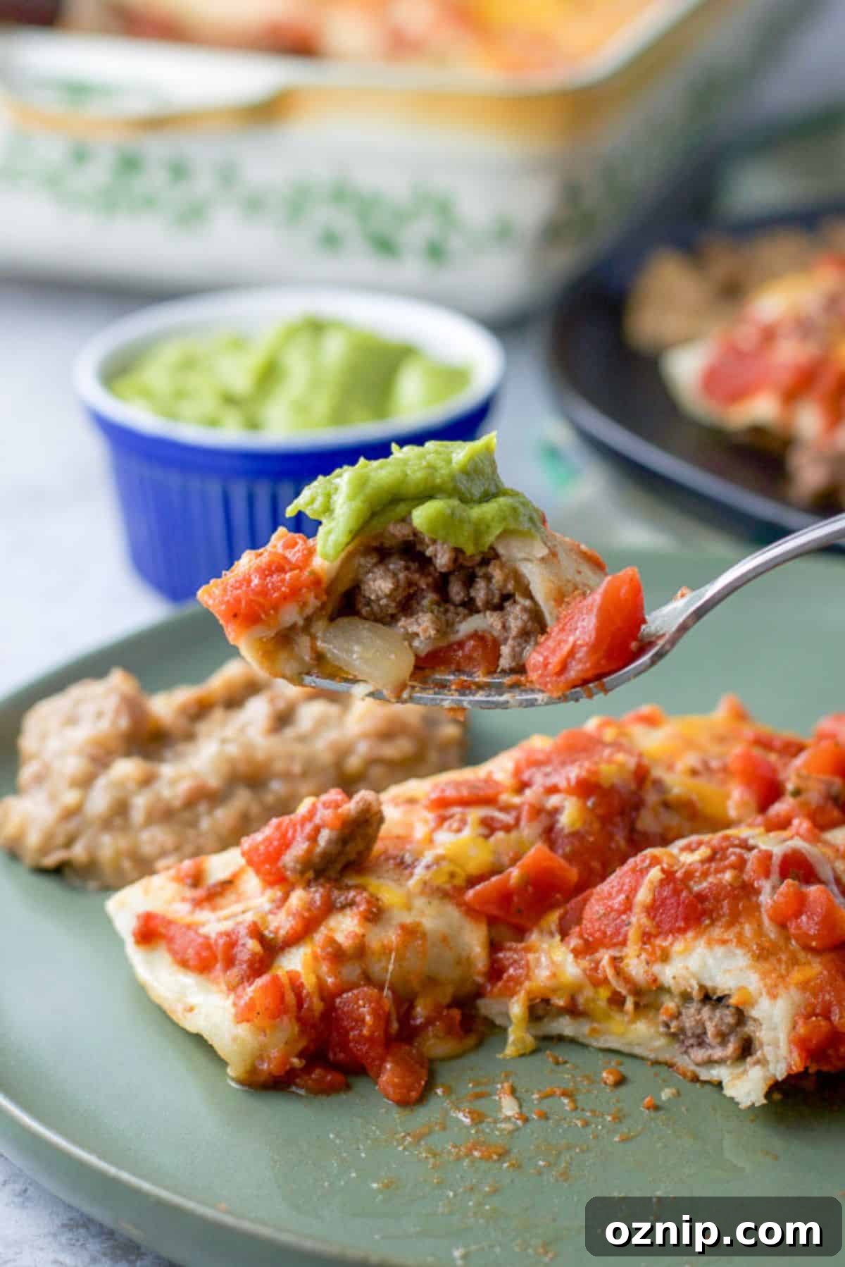 Cheesy Ground Beef Enchiladas with Red Sauce 9 Forkful of a bite of beef enchiladas ready to be eaten.