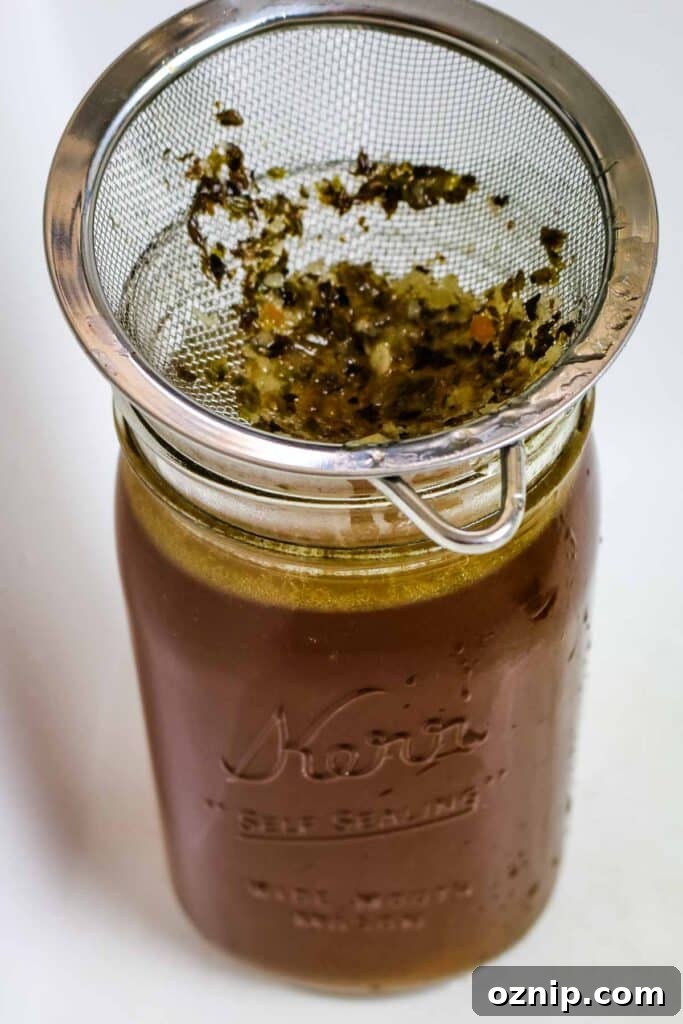 running broth through sieve in mason jar.