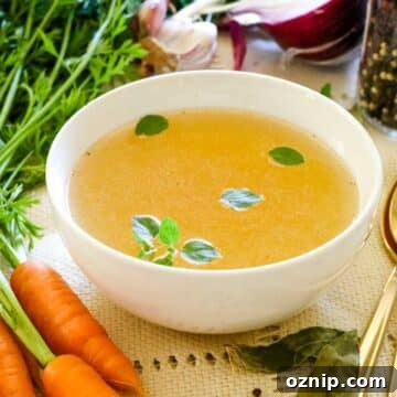chicken bone broth in white mug with carrots.