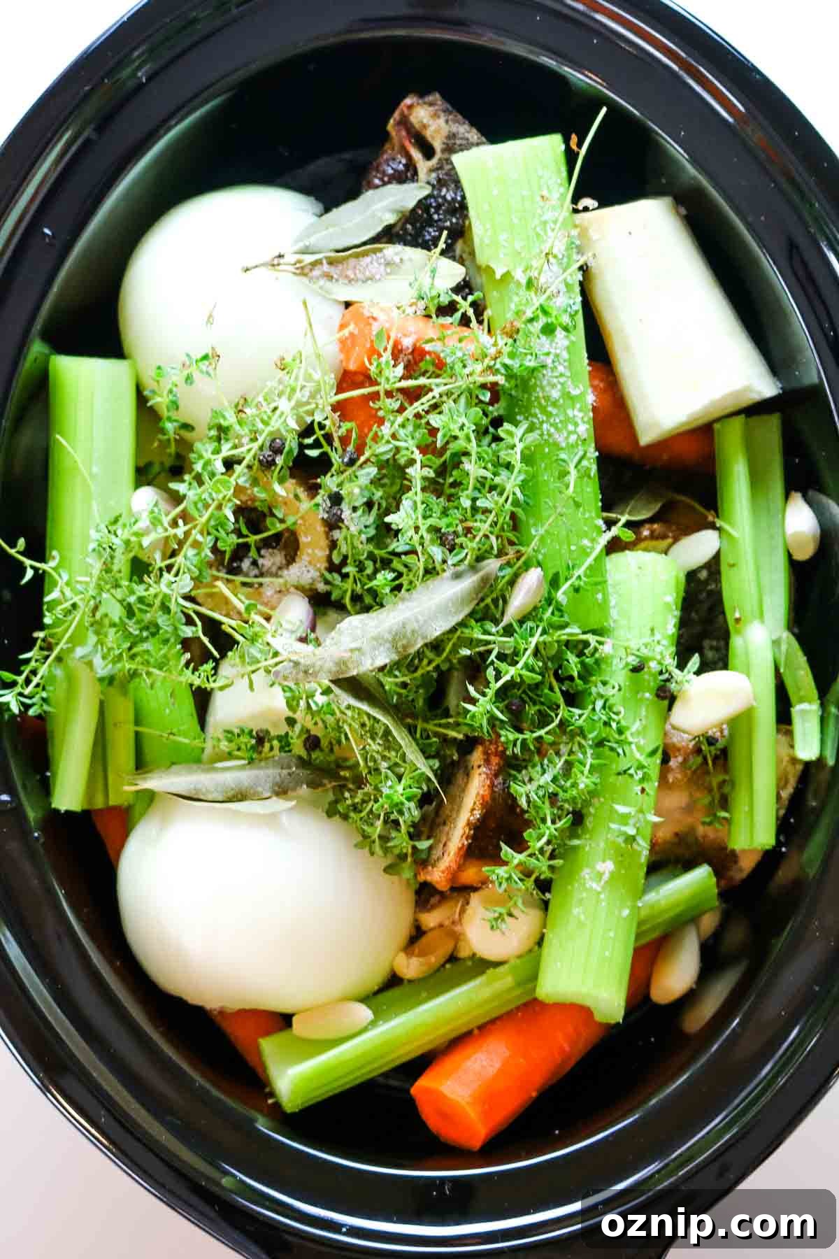 vegetables added to beef bone broth in slow cooker.