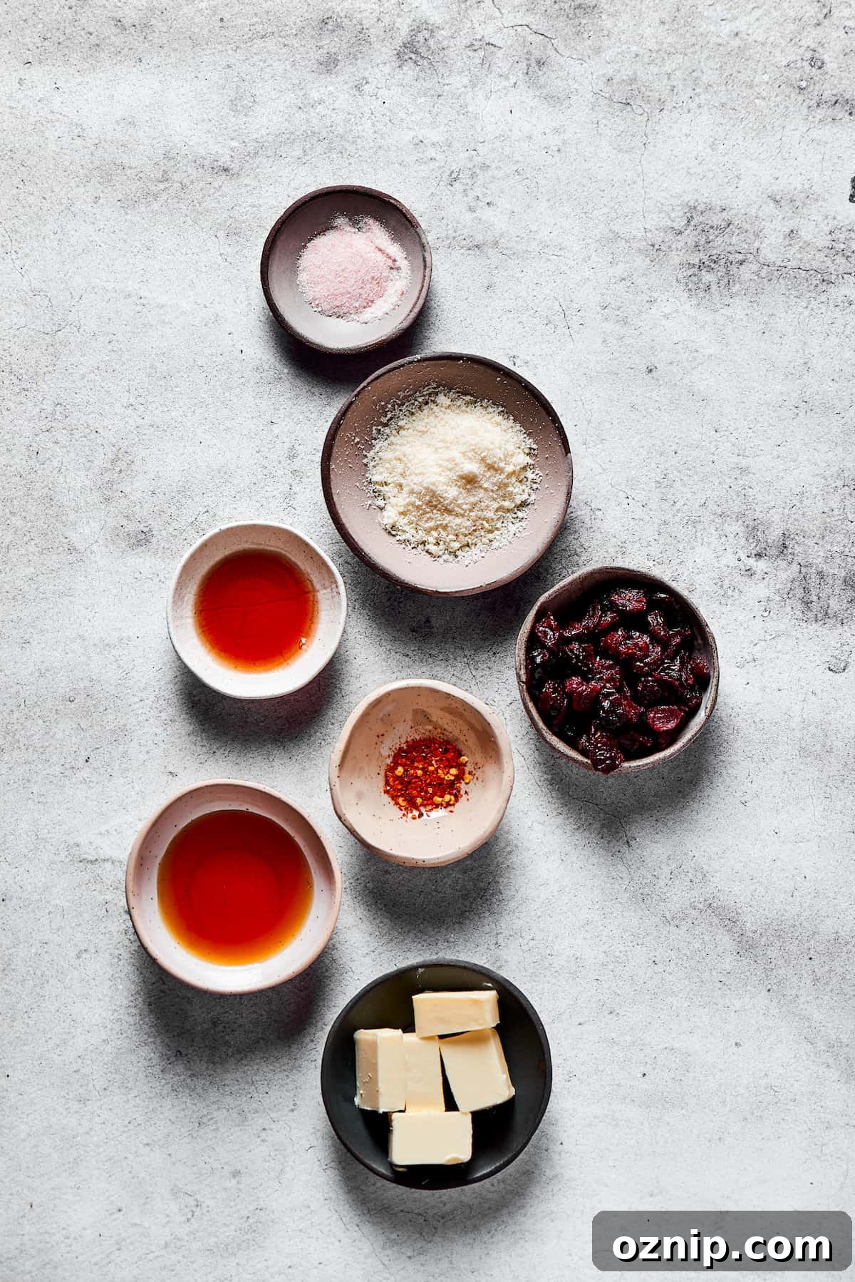From top: Salt, parmesan cheese, dried cranberries, chili flakes, butter, maple syrup, pomegranate vinegar.