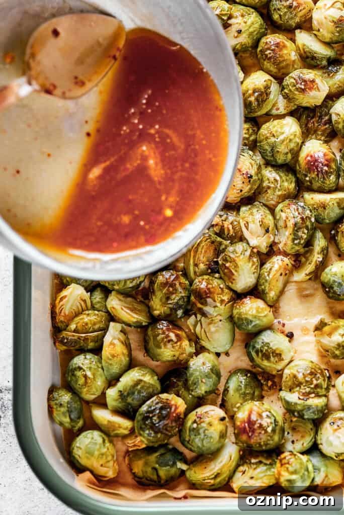 Adding glaze to roasted brussel sprouts.
