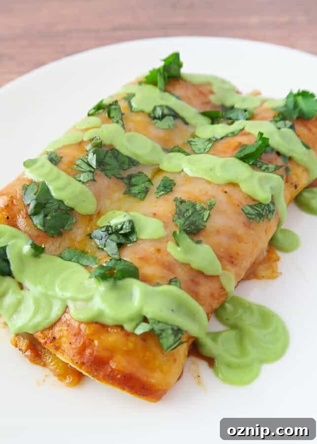 Healthy Creamy Avocado Sauce (with Greek Yogurt) drizzled on a red chicken enchilada