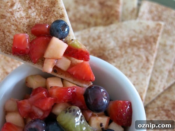 Low Sugar Apple Berry Salsa with Cinnamon Chips 11 Cinnamon Chip dipping into bowl with Fruit Salsa