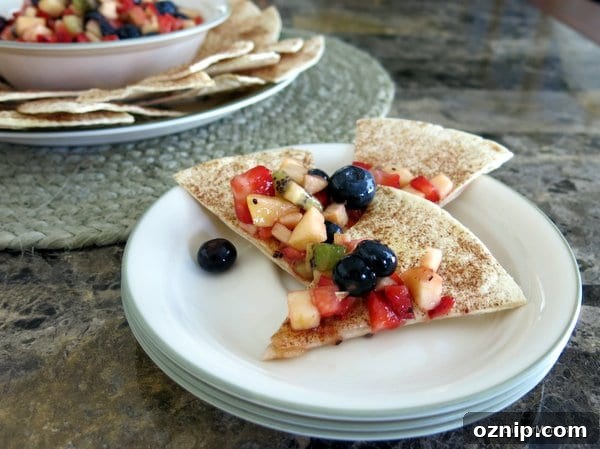 Low Sugar Apple Berry Salsa with Cinnamon Chips 10 Fruit Salsa on top of cinnamon chips on a stack of plates.
