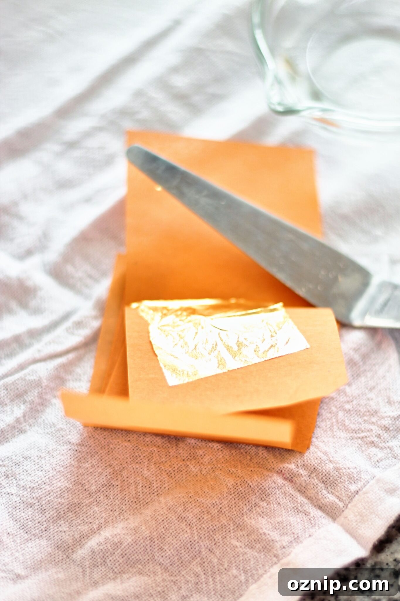 preparing to add gold leaf to cakes