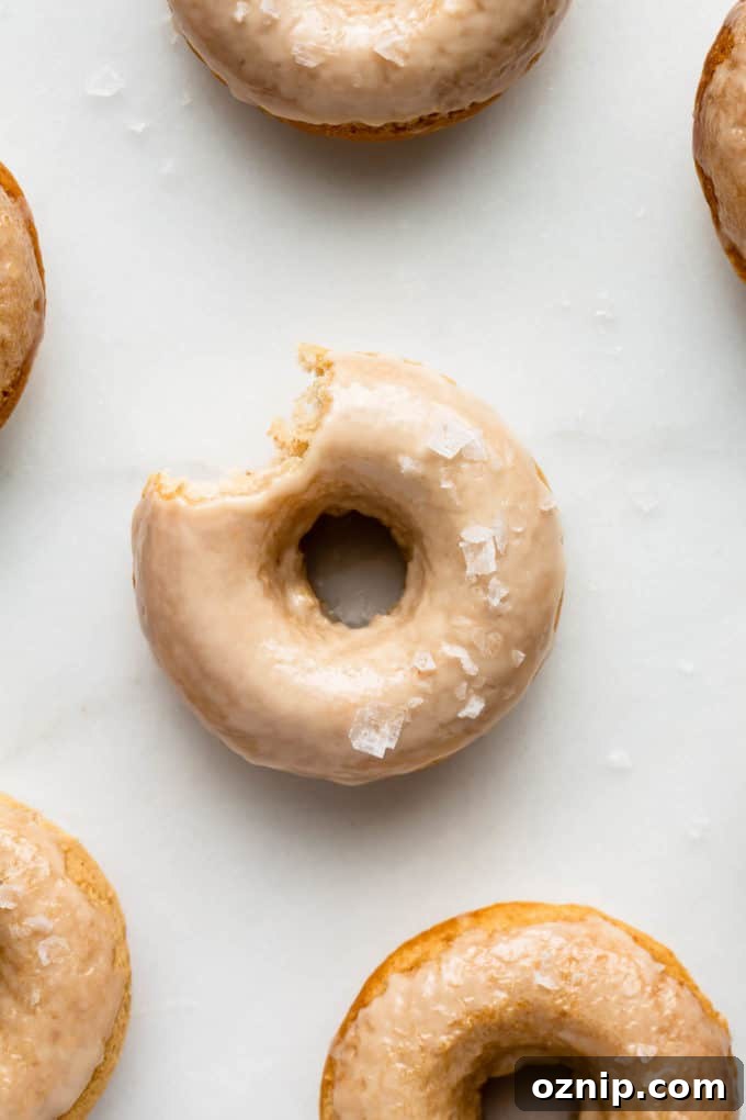 Vegan Salted Maple Donuts with Maple Glaze 4 Maple donuts on a marble board topped with sea salt