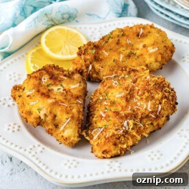 Air Fryer Parmesan Crusted Chicken Recipe 9 3 pieces of Air Fryer Parmesan Crusted Chicken on a white plate