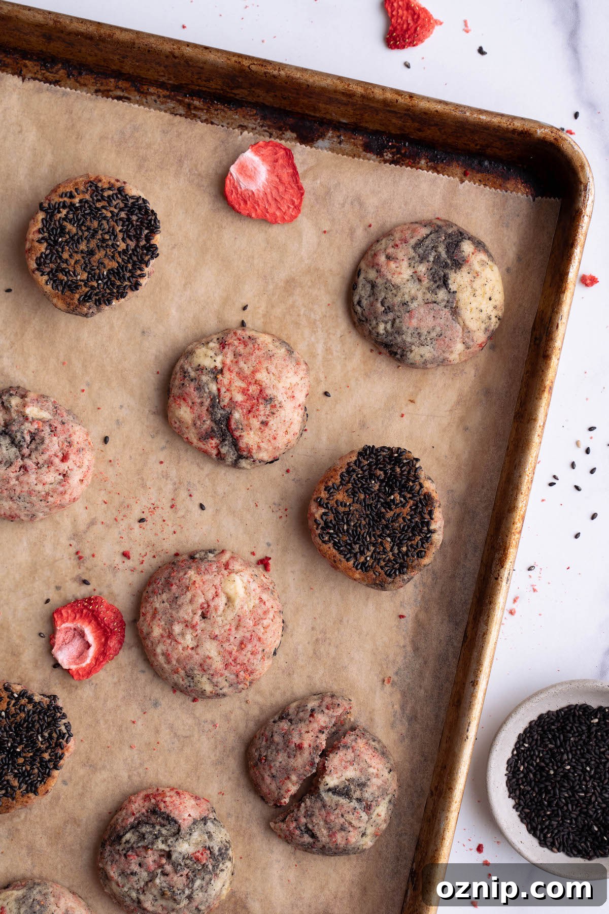 Strawberry black sesame cookies on a baking sheet