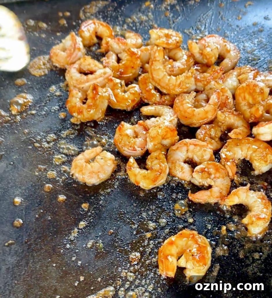 Finishing glazed shrimp on a griddle.