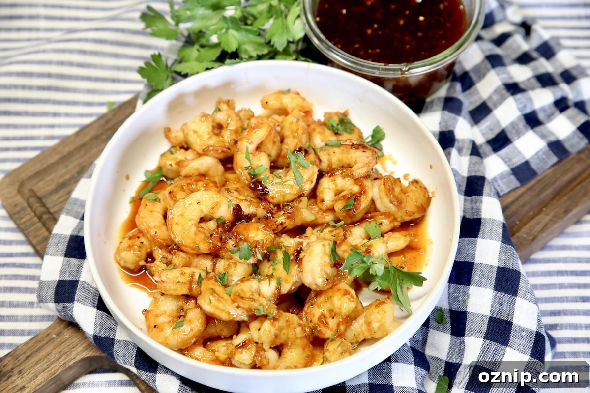 Bowl of glazed shrimp on a cutting board.