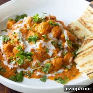 close-up of butter tofu paneer in a bowl with naan