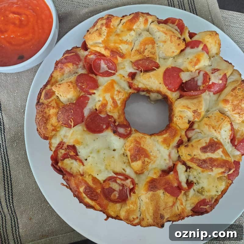 30+ Side Dishes for Soup to Complete Your Meal 17 Pepperoni Pizza Monkey Bread on a white plate next to a bowl of marinara