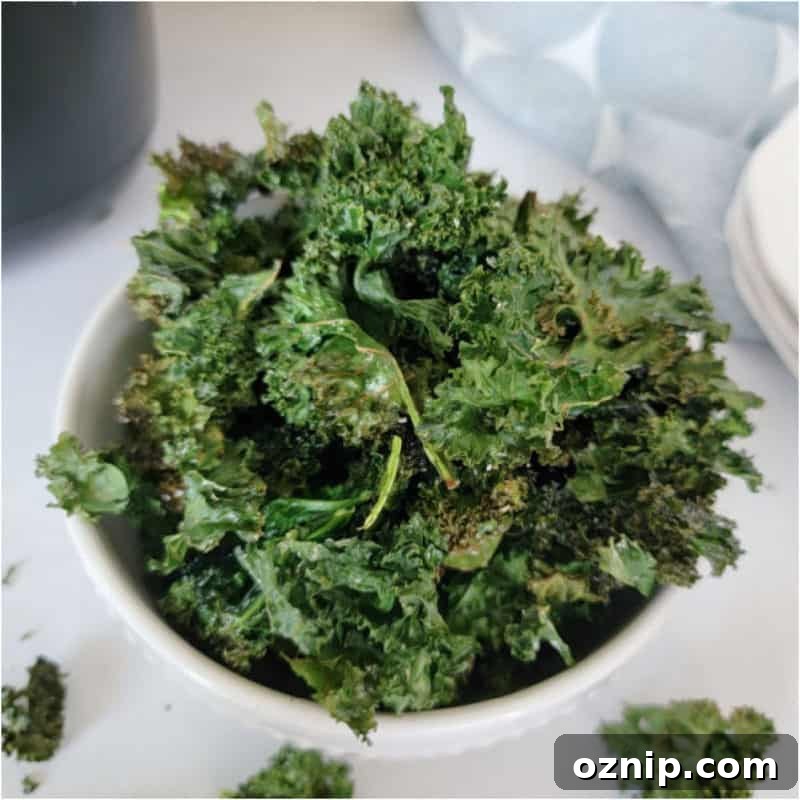 30+ Side Dishes for Soup to Complete Your Meal 27 Air Fryer Kale Chips in a white bowl by a cloth napkin