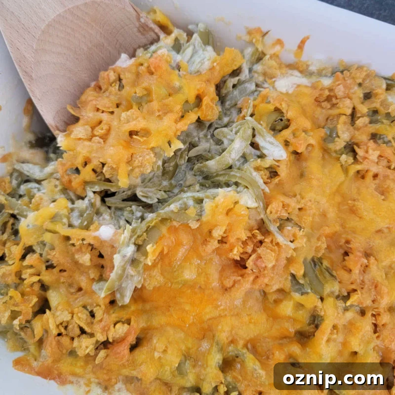 30+ Side Dishes for Soup to Complete Your Meal 32 wooden spoon scooping cheesy green beans from a white casserole dish