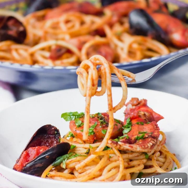 Bucatini Seafood Pasta (Shrimp, Scallops, & More) on fork above bowl.