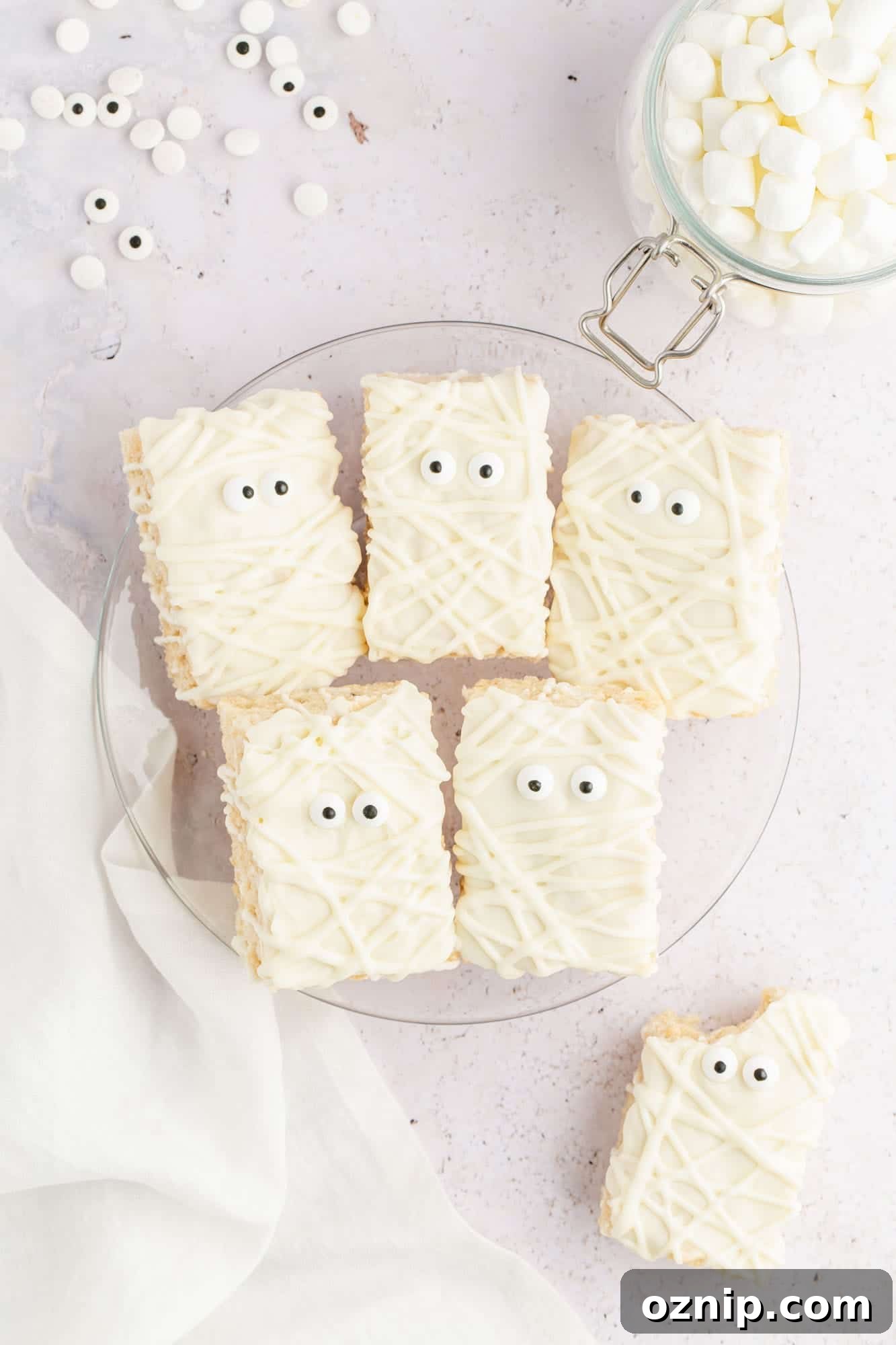 Overhead shot rice krispie treat mummies on a glass plate