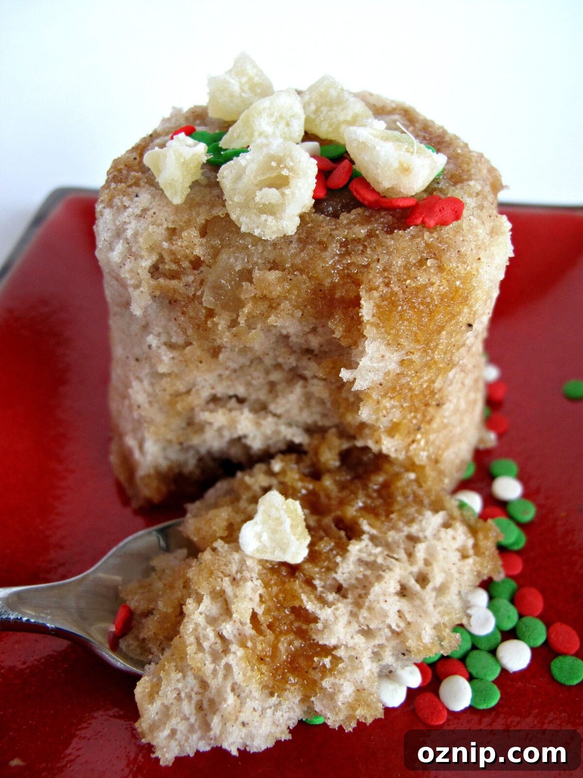 Gingerbread Mug Cake with Crystallized Ginger and Caramel Syrup A spoonful of Gingerbread Mug Cake in front of the mug cake on a plate.