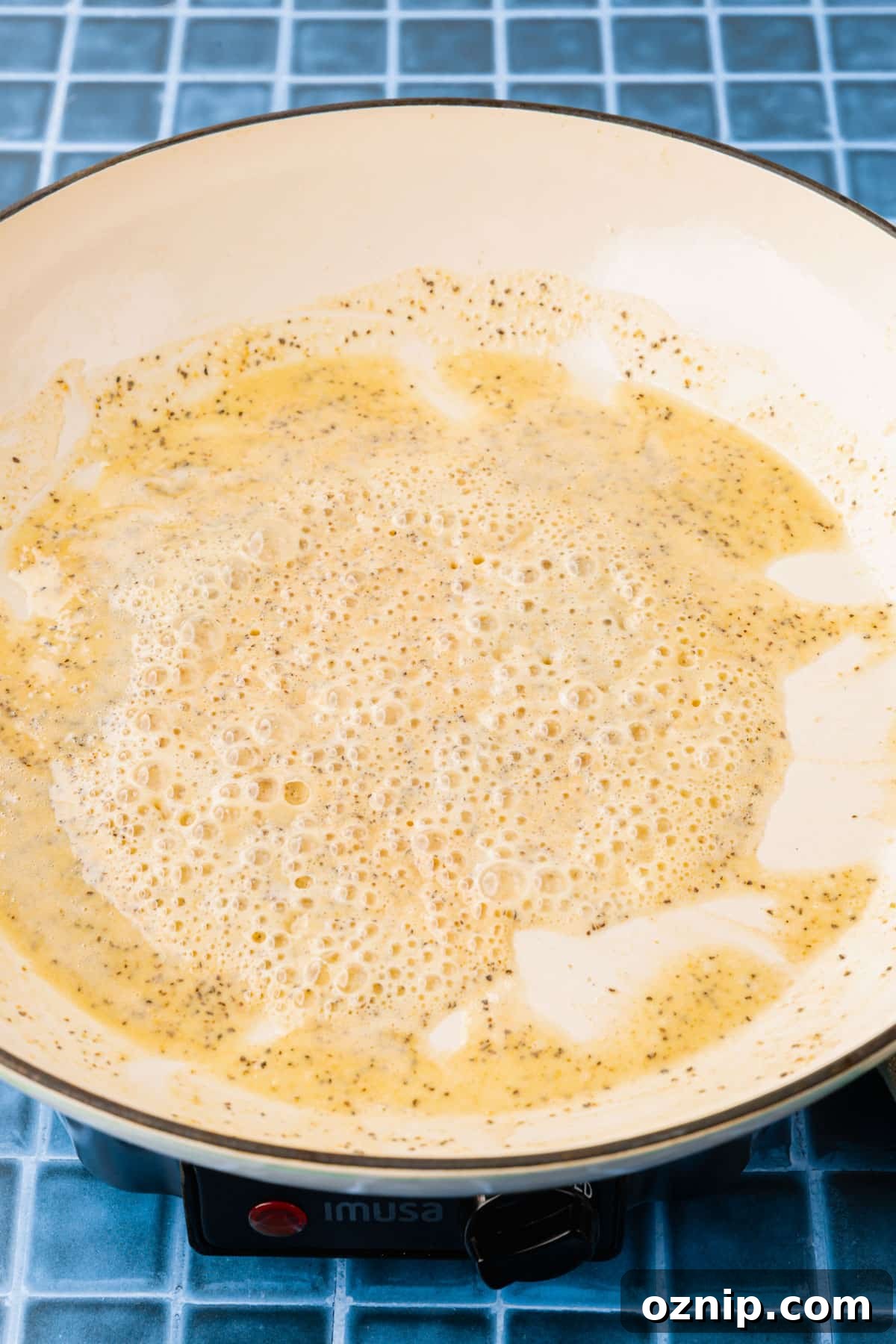 Creamy Gluten Free Mac and Cheese Recipe 6 A gluten free roux in a white pan that is bubbling up and golden brown.
