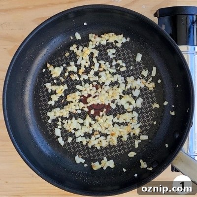 Feta Shakshuka Recipe with Poached Eggs 4 onions cooking in a pan
