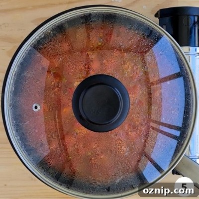 Feta Shakshuka Recipe with Poached Eggs 8 shakshuka sauce simmering with a lid on