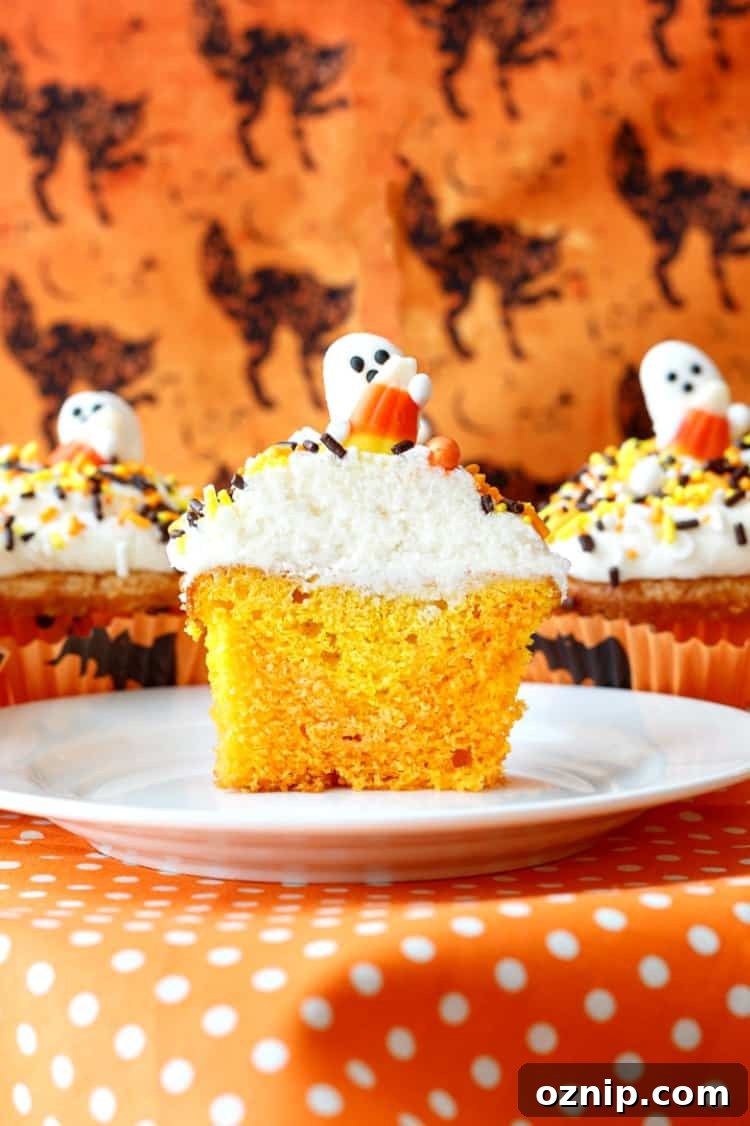 A cross section of a candy corn cupcake showing interior of cake colors.