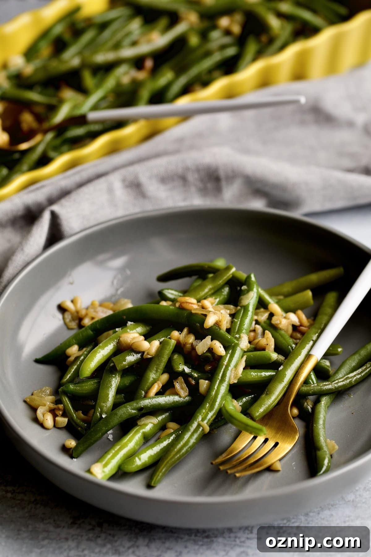 Sautéed Frozen Green Beans Recipe (Easy) on a grey plate with a fork