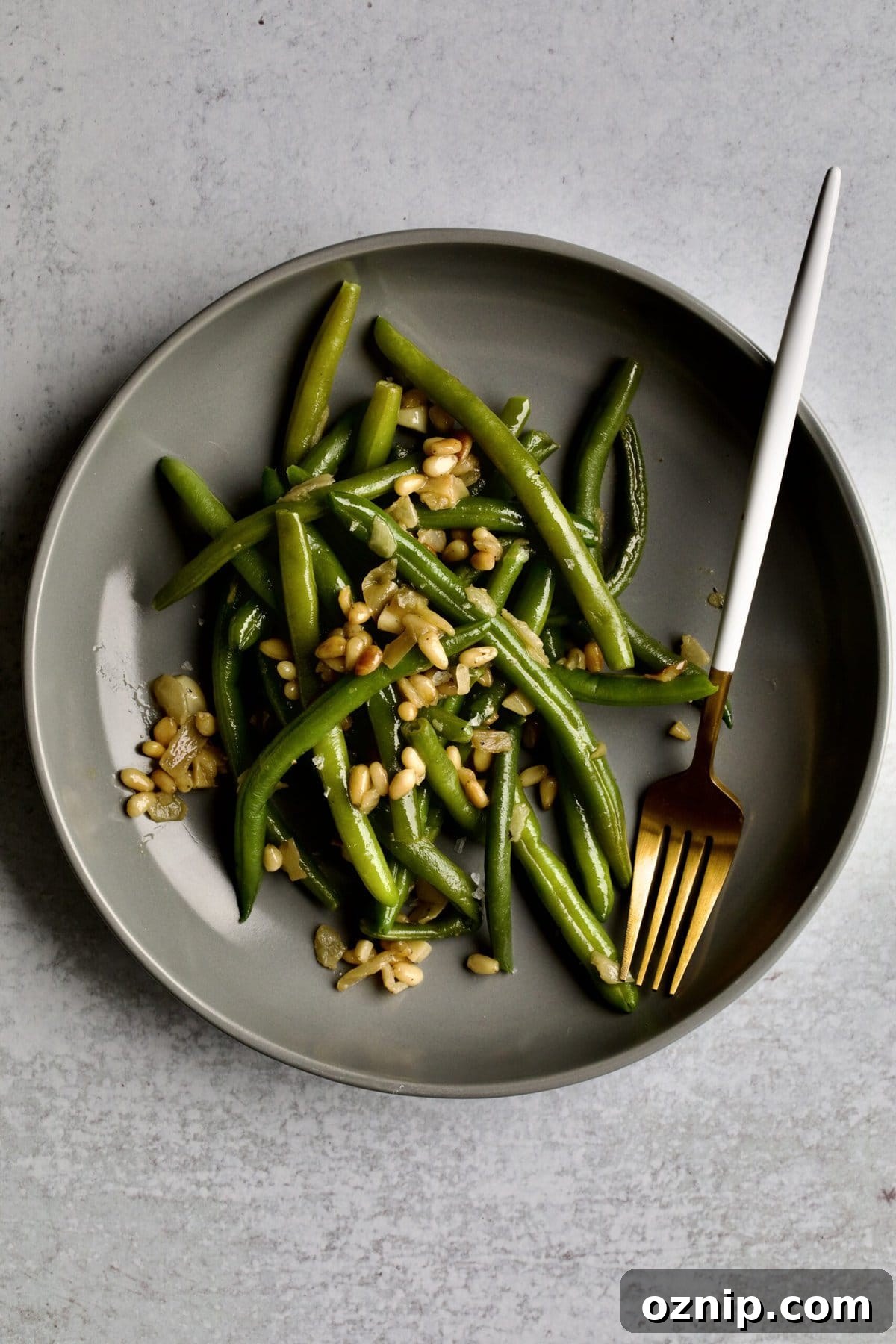 Sautéed Frozen Green Beans Recipe (Easy) on a grey plate with a fork.
